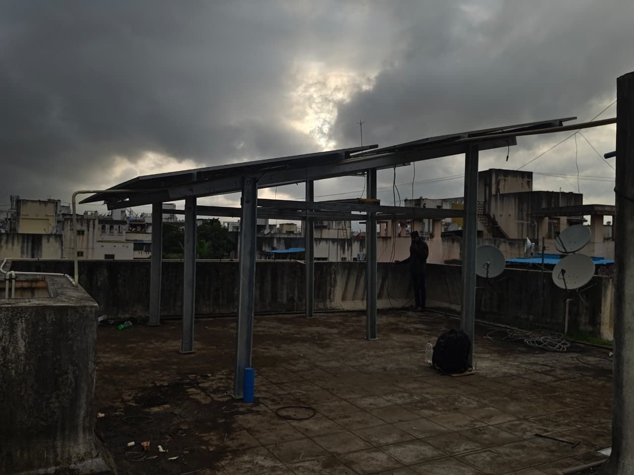 Rooftop mounting structure with panels partially installed at dusk